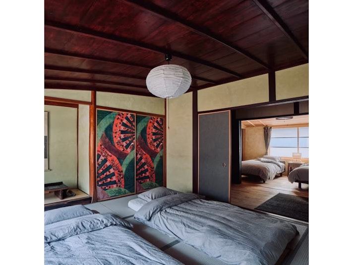 手前和室に布団4組、奥にシングルベッド２台