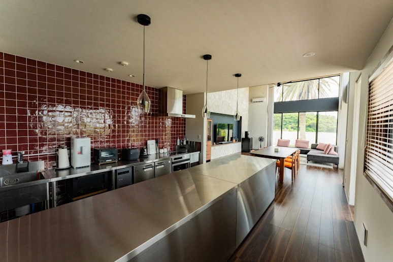 赤いタイルとステンレスが映える、機能美溢れるキッチンスペース。...