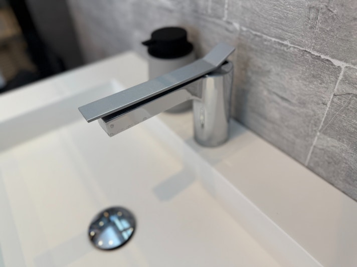 シンプルでモダンなデザインの金属製蛇口が取り付けられており、洗面まわりのスタイリッシュな雰囲気...