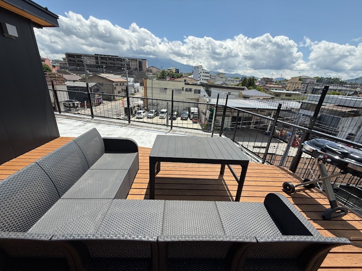 広々とした屋上やバルコニーの露天スペース。開放的な空と青空の下、快適なアウトドア用のソファーや...