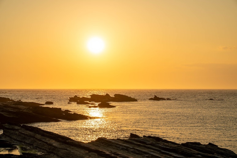水平線に沈む夕日が一日の終わりを美しく彩ります。...