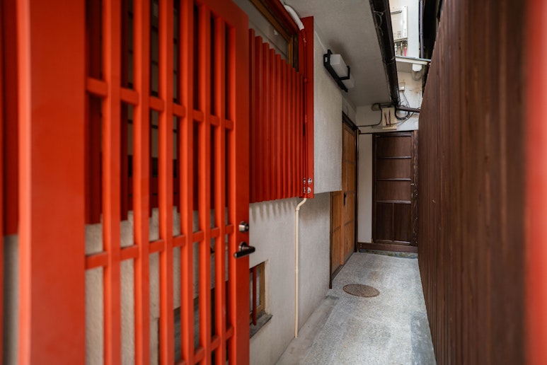 自然光に包まれた玄関アプローチ。木の温もりと石畳のコントラストが、和の趣を演出します。