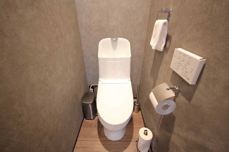 清潔で快適なトイレ。タオル掛けやストッカーを備え付け、機能性も重視しています。