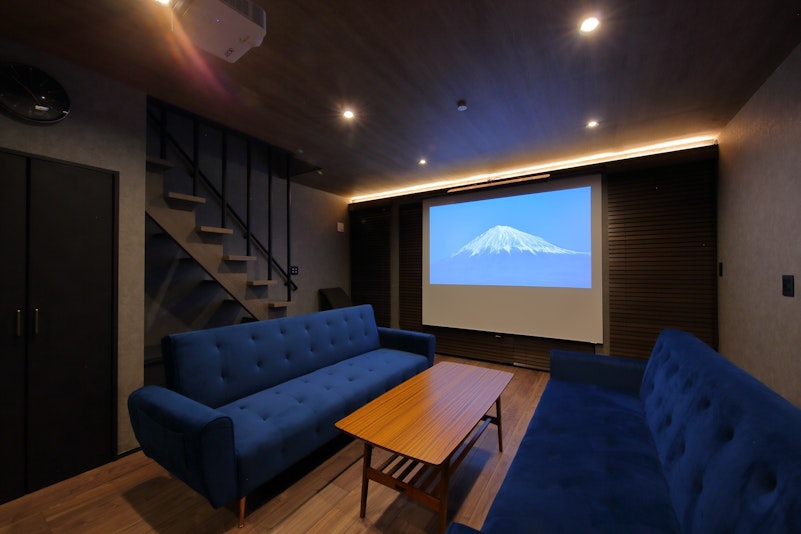 1階リビングでは、100インチの大型スクリーンに、4K対応のプロジェクターから映し出される大迫...