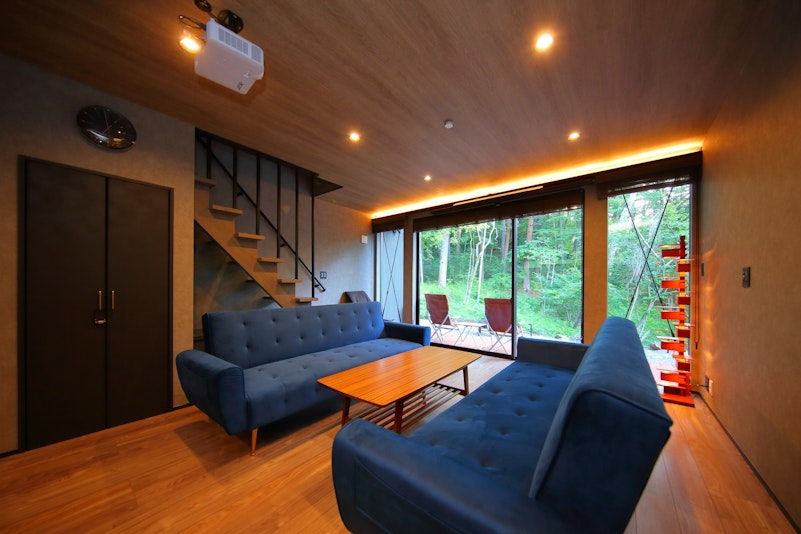 壁一面に広がる大きな窓からは、緑豊かな森の景色が望めます。そのままデッキに出られるので、自然の...