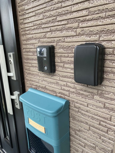 玄関フード内、ご宿泊者様専用ドアの右側(ポストの右上)に黒いキーボックスが設置されています。