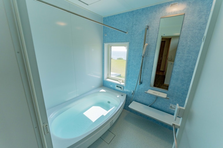 開放感溢れるバスルームからは雄大な景色を一望できます。朝の光や夕暮れの色彩に包まれる入浴体験は...