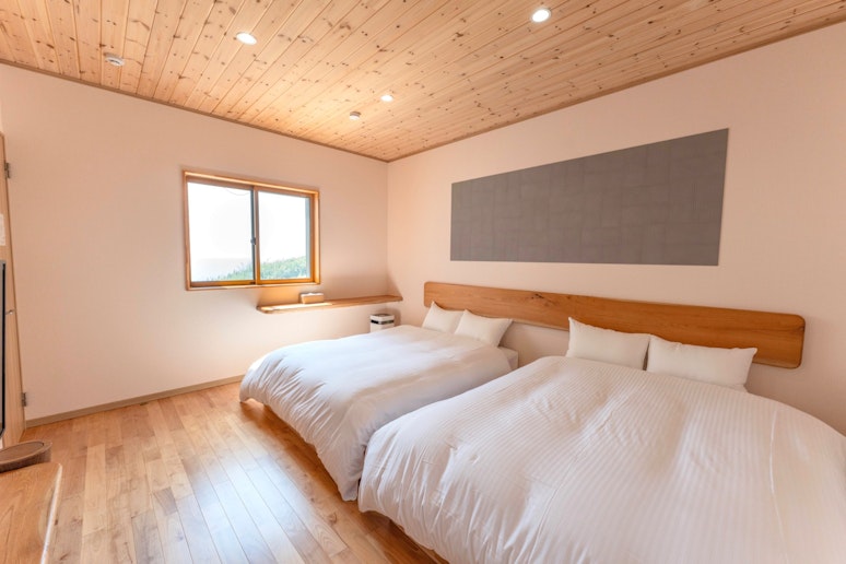 朝のベッドルームは柔らかな光に包まれ、窓からはオーシャンビューを堪能いただけます。