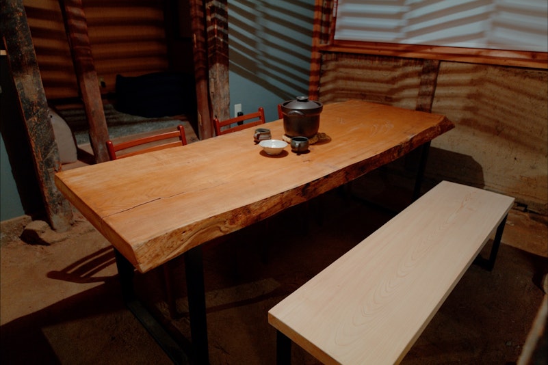 土鍋でご飯を炊き、天然板のダイニングで仲間と食事。