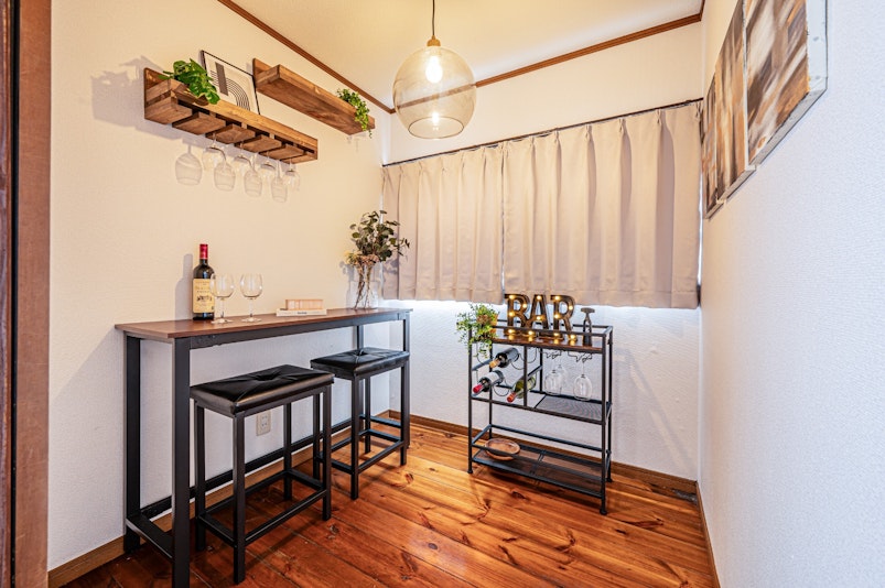おしゃれなハイテーブルとカウンターチェアが並ぶ、隠れ家風のバーコーナー。