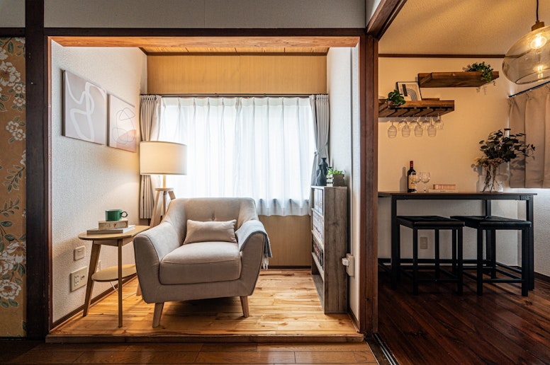 明るい窓辺に置かれた一人掛けソファ。読書やワインを片手にリラックスできる隠れ家のような空間です。