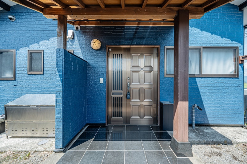 鮮やかなブルーの外壁が印象的な一軒家。広々とした玄関ポーチは清潔感があり、旅の始まりを迎えるの...