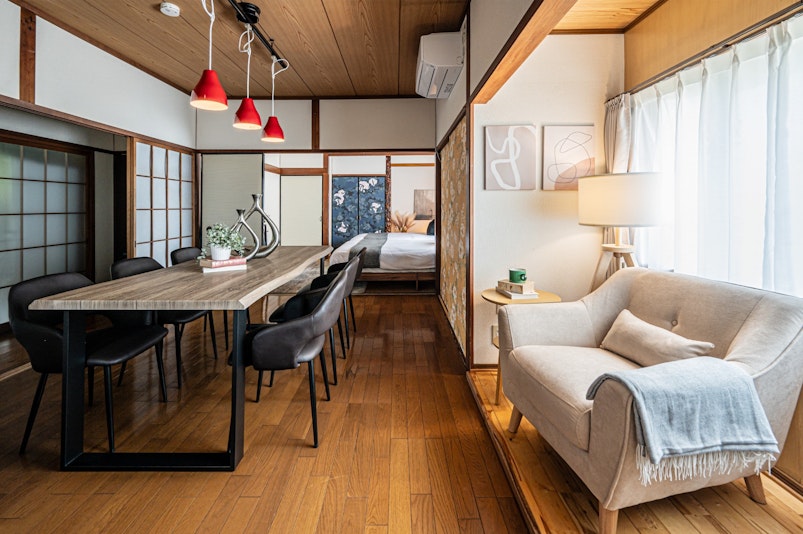 陽光が差し込む広々リビング。畳の和室とモダンなソファが調和し、家族や仲間との団らんにぴったり。