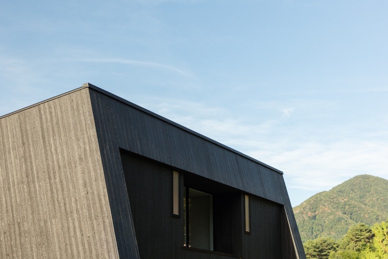 雄大な山々を背景に佇むモダンな建築。自然との調和を体感