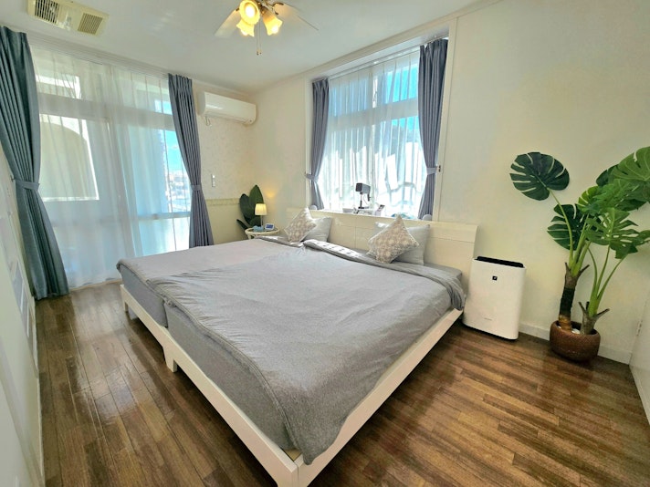 セミダブルベッド2台をハリウッドツインスタイルで提供する寝室1です。南国らしさを感じられるイン...