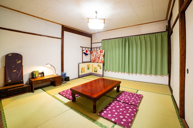 ８畳間の和室には文机と鏡台が置かれています。お休みの際はテーブルを廊下に移動して押し入れから布...