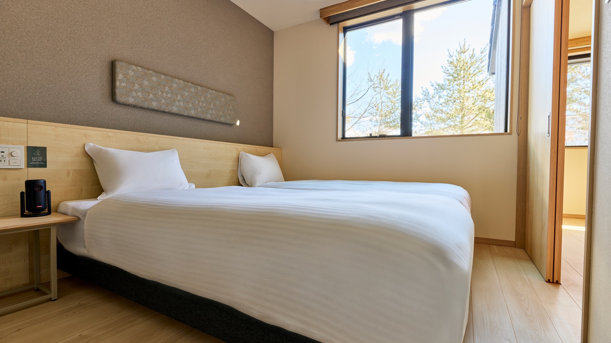 【E：寝室】落ち着いた雰囲気の寝室。シングルベッドを2台設置