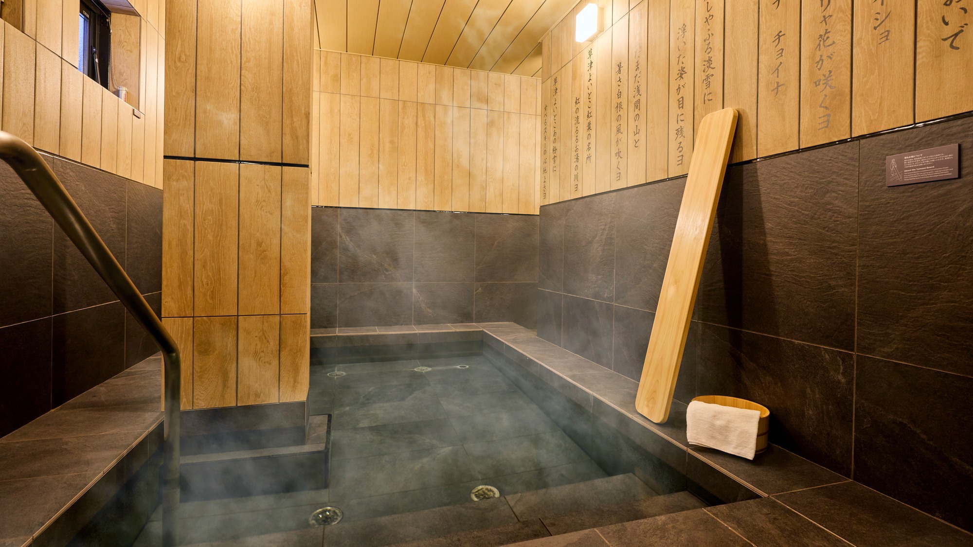 【A：風呂】草津節が印象的な大浴室。縁に座り足湯やドリンクを楽しむのも◎(温泉ではありません)