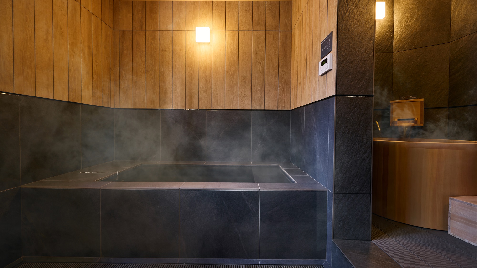 【C/D：浴室】万代鉱源泉(檜風呂)を楽しみながら、休み湯として真湯の石風呂を。