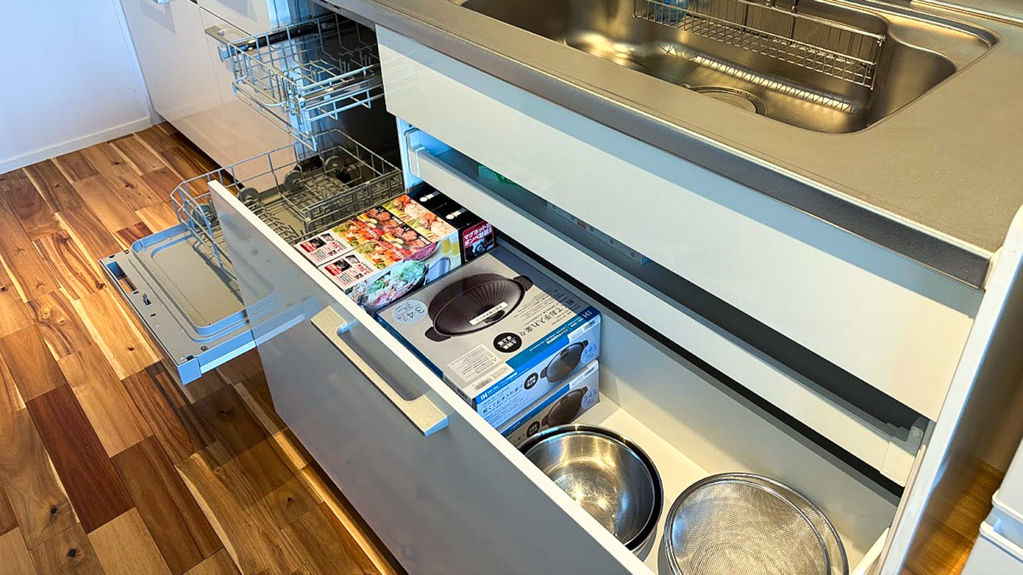 ・【キッチン】ザルやボウルの他、カセットコンロとお鍋もご用意。真ん中にある食洗機もご利用いただけます