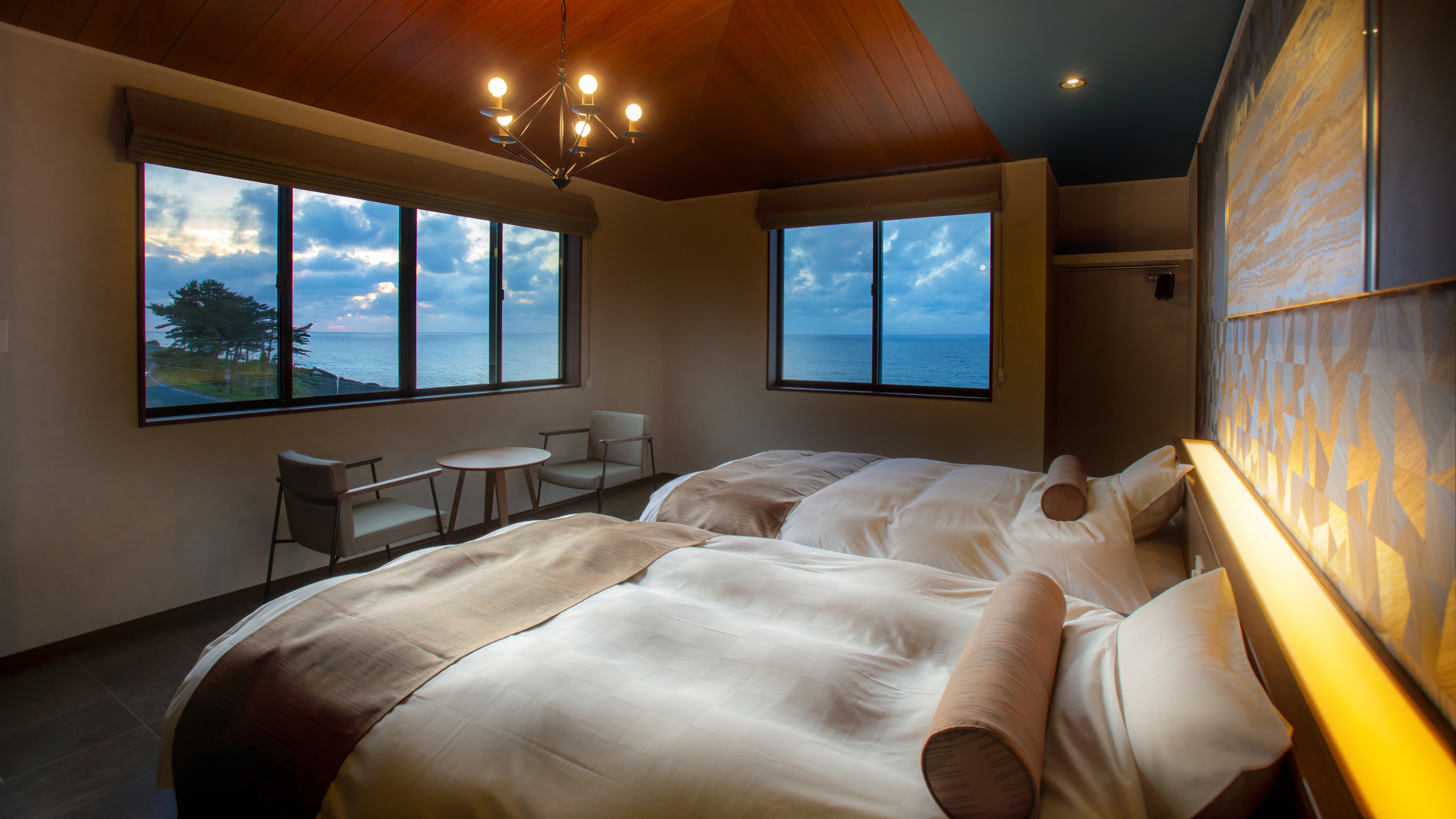 【客室・2階西側客室】セミダブルのシモンズベットが２台、大きな窓からは雄大な日本海の絶景を一望。