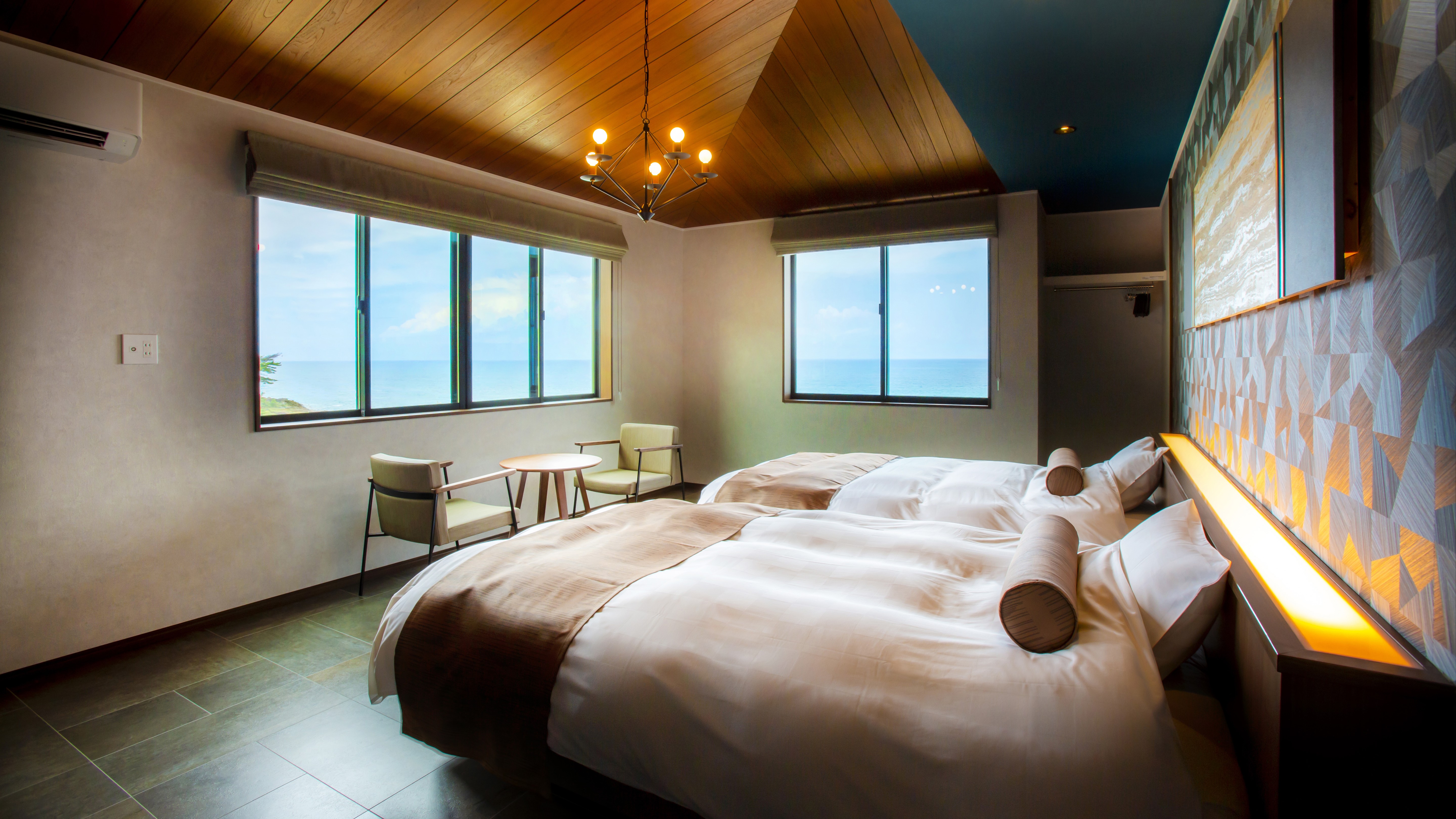 【客室・2階西側客室】セミダブルのシモンズベットが２台、大きな窓から雄大な日本海と日本海に沈む夕日を