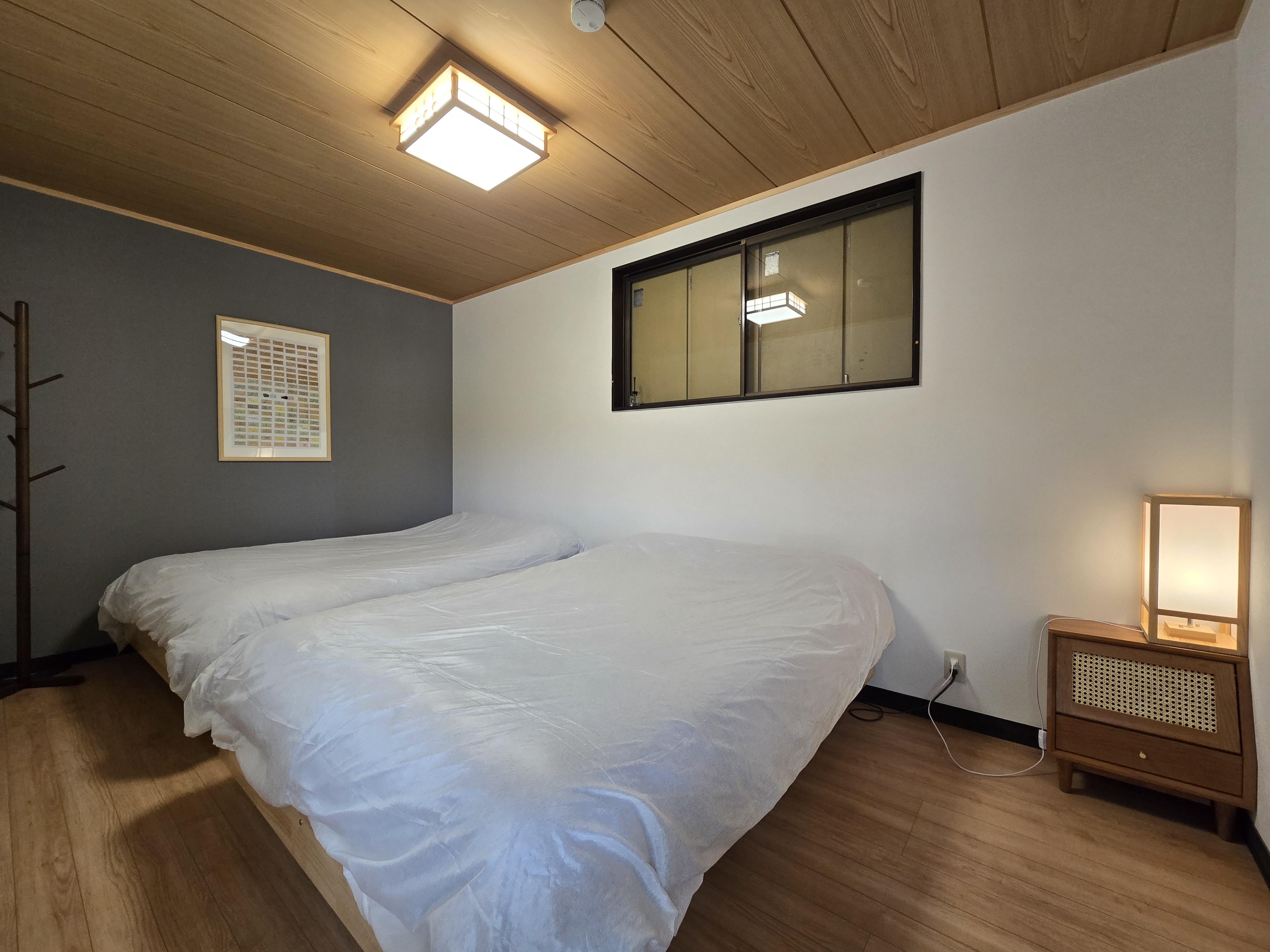 木とモノトーンが調和した、シンプルで美しい和洋折衷の寝室空間