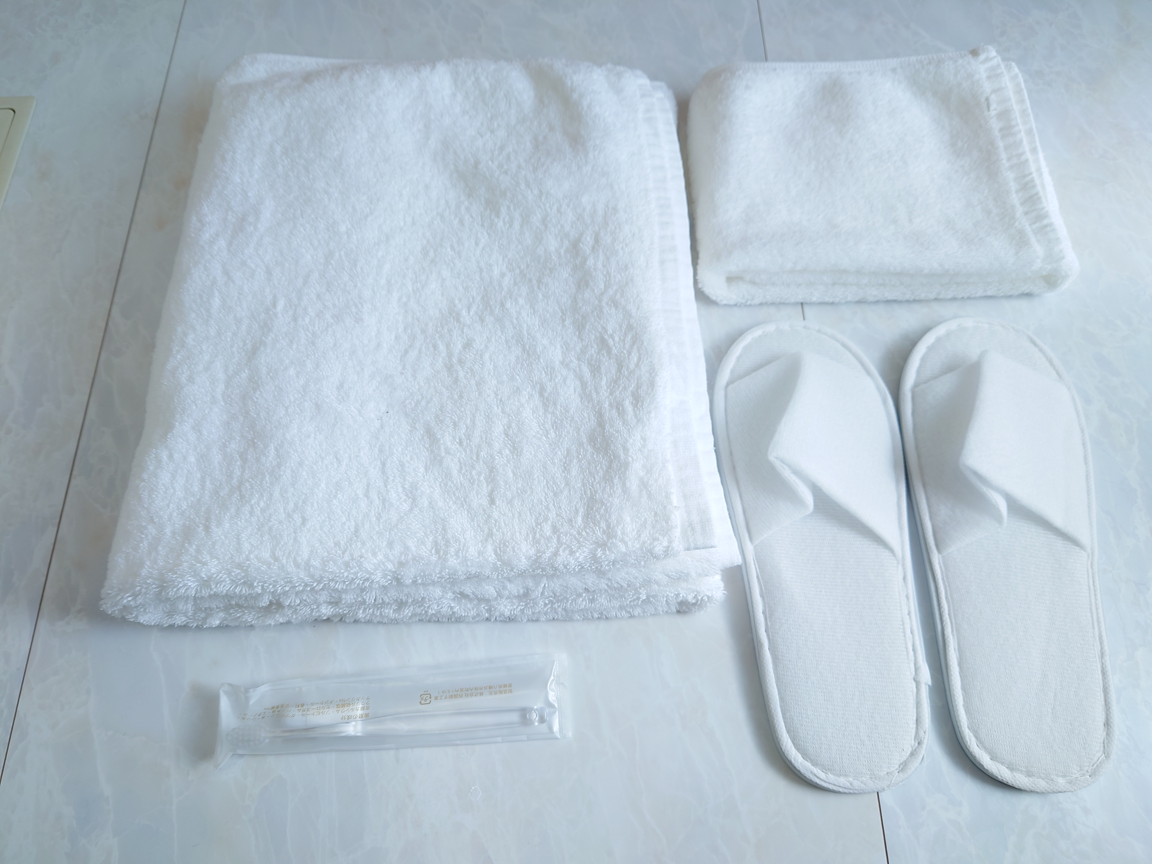 清潔にクリーニングされた100％コットンのバスタオル、フェイスタオル。 使い捨てスリッパ。 歯磨きセット。