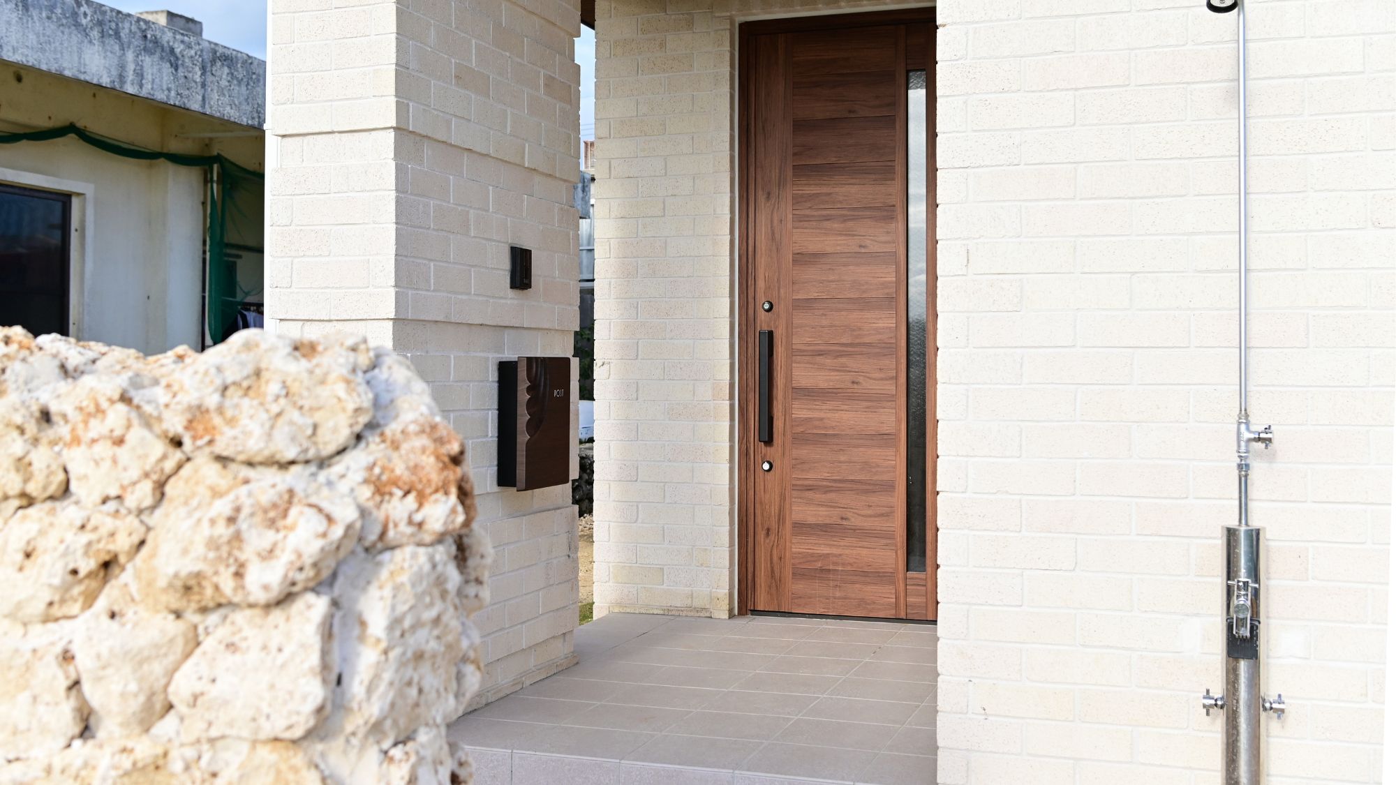 シンプルでスタイリッシュな玄関。石壁がアクセント。