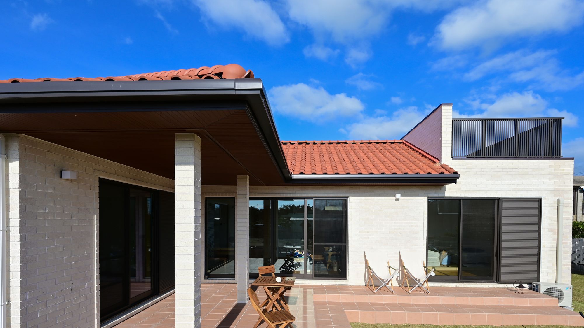 赤い屋根が印象的な明るい昼間の外観。