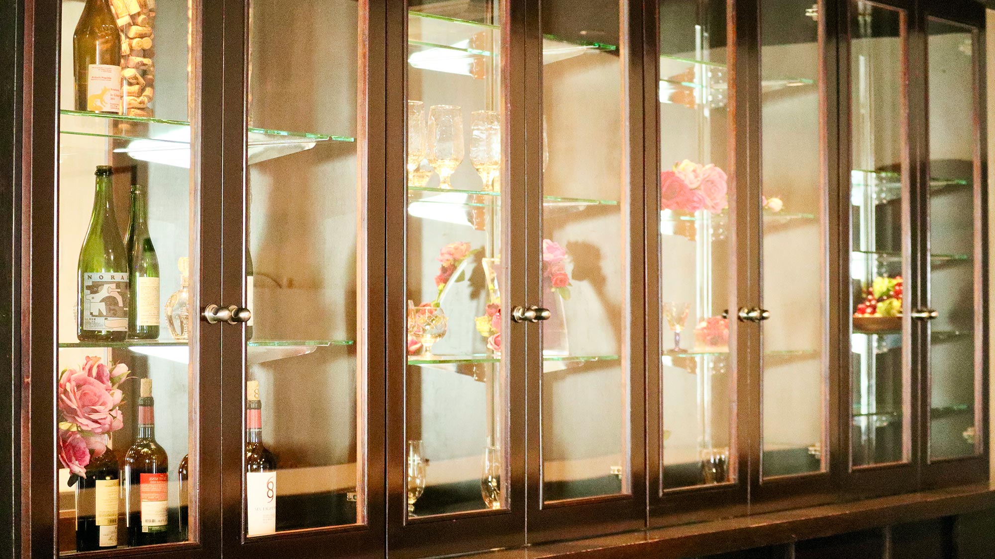 ・【キャビネット】元スナックの名残を感じるキャビネット。お花やお酒、グラスが美しく飾られています