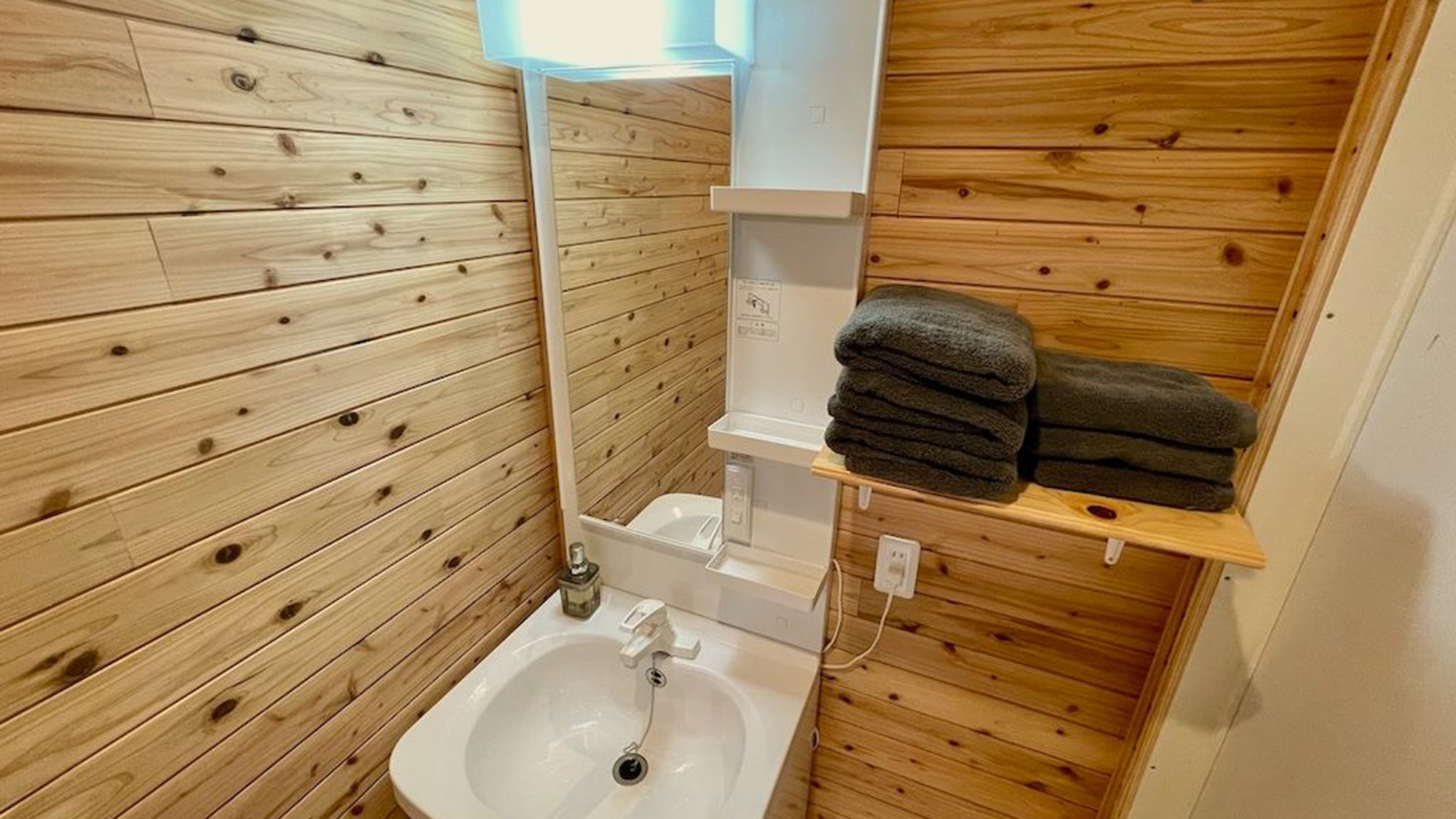 ・【洗面所】木目が美しい壁に囲まれた、シンプルで温かみのある洗面所