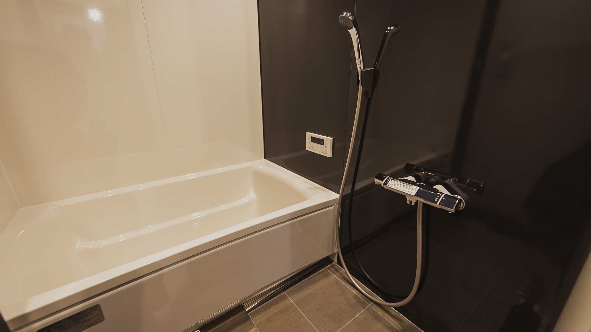 ・【浴室】ブラックの壁がシックな雰囲気を漂わせる浴室。湯船でじっくりとお温まりください