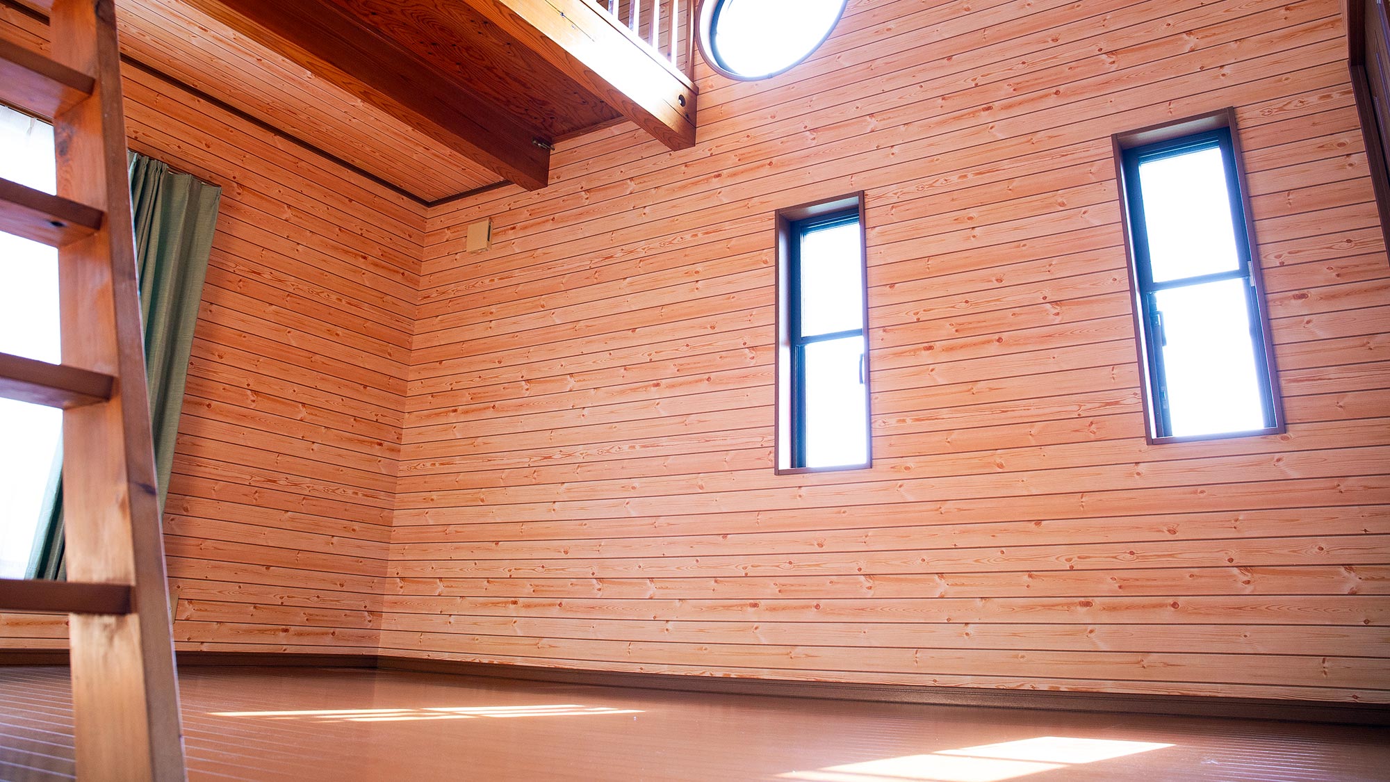 ・【2階洋室／西】無垢材の梁と円形の窓が印象的な西側の洋室