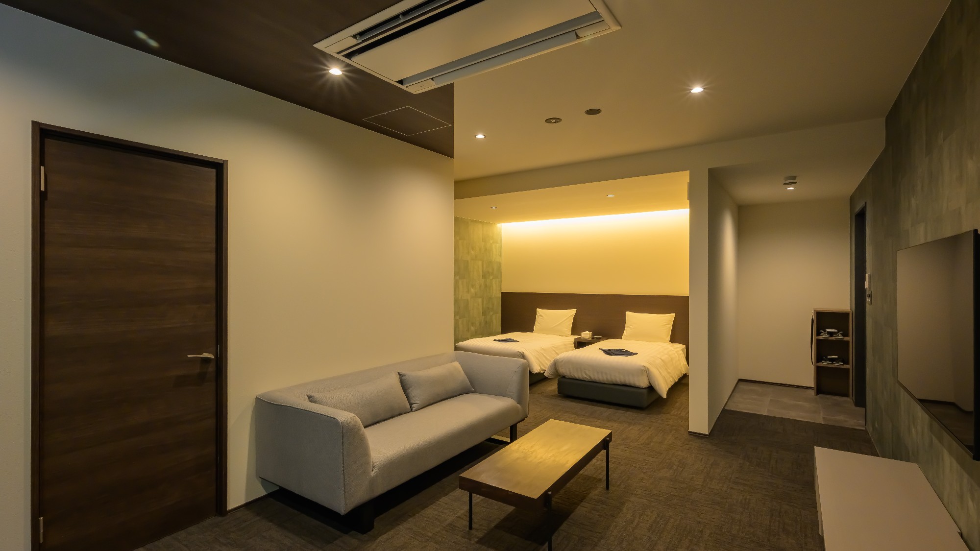 【デラックスツイン】緩やかに区切られたリビングスペースとベッドルーム。