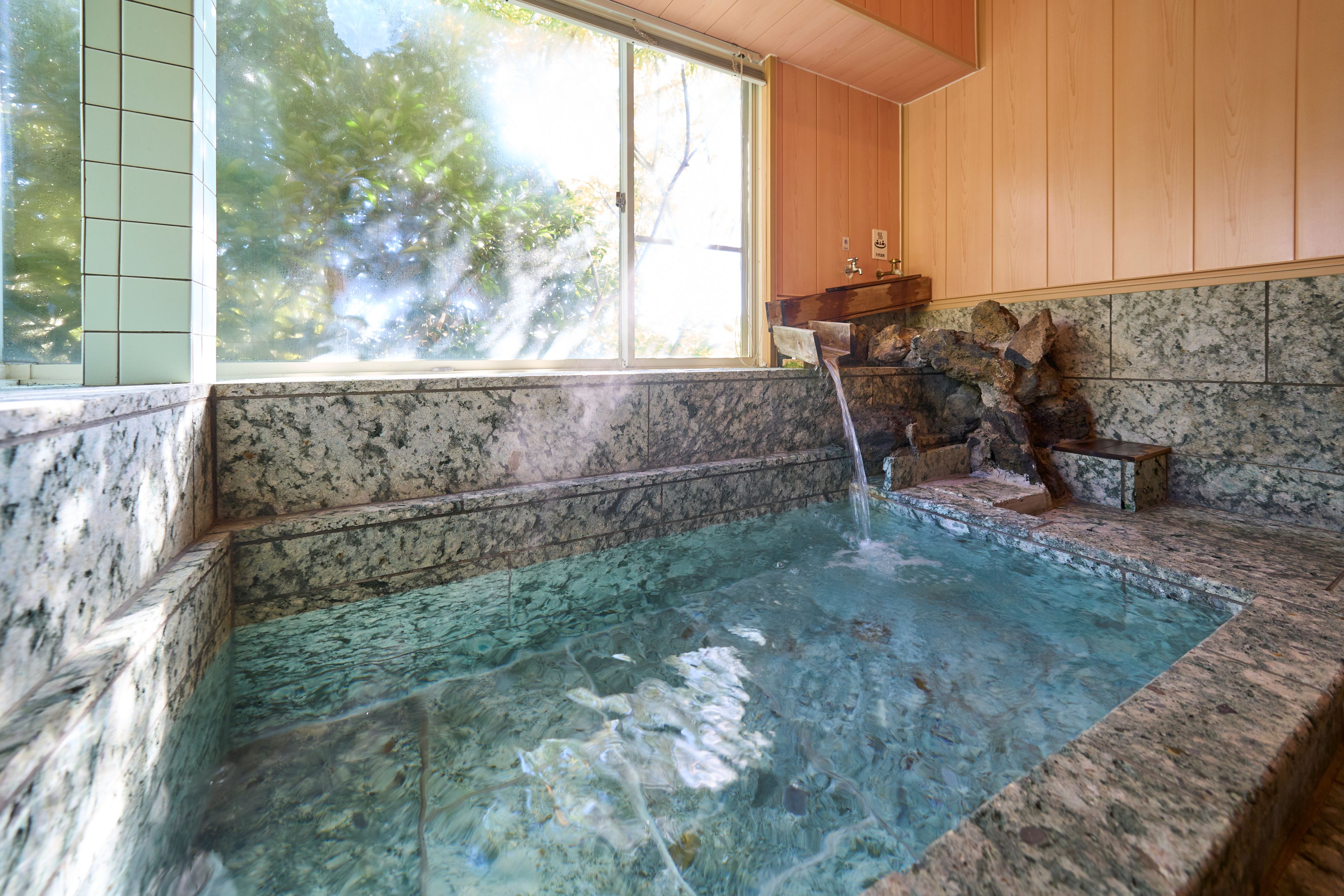 【温泉】窓から光が差し込む開放的な浴室。天然温泉の湯で心身ともに癒されます。