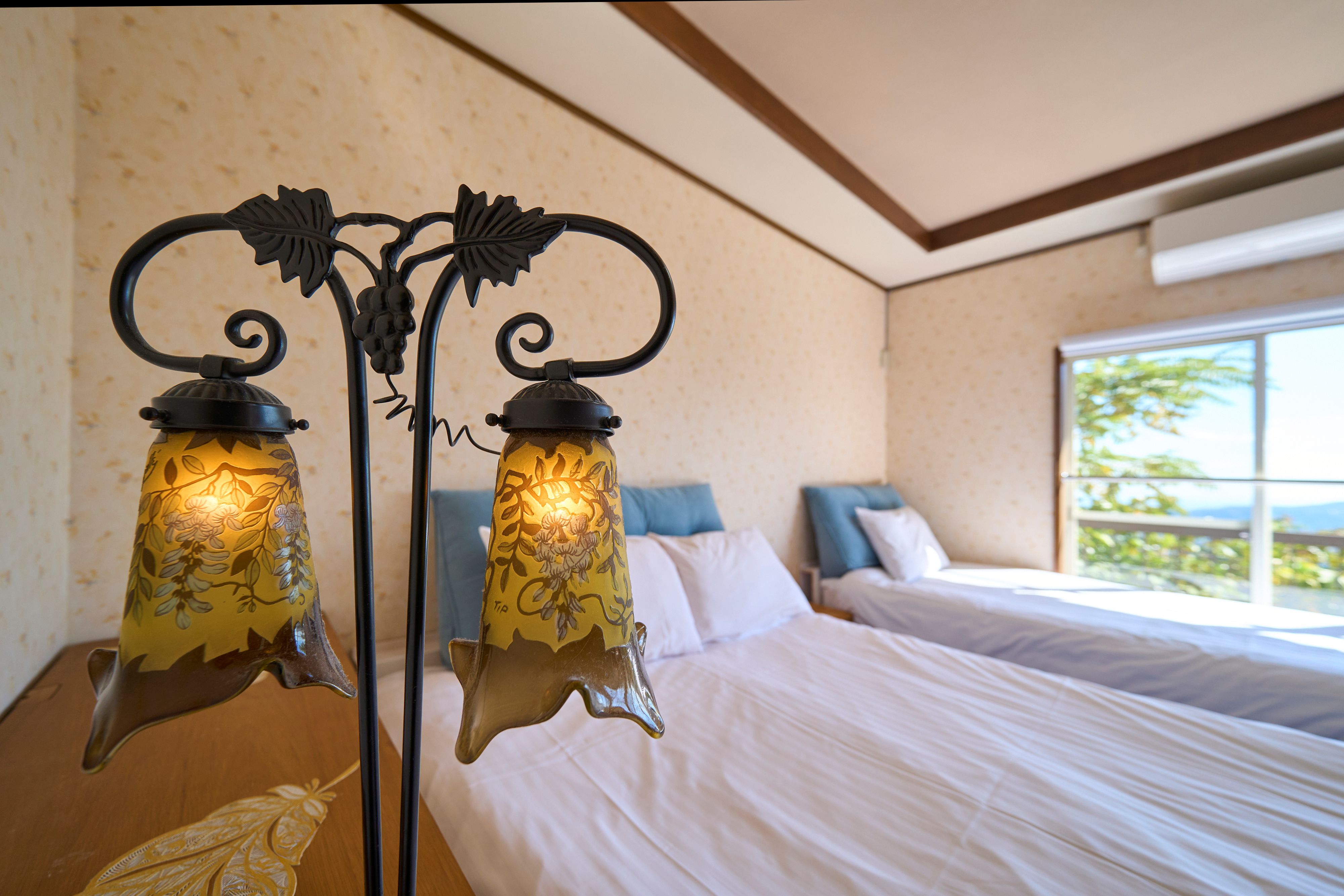 【寝室①】ダブル&times;１、シングル&times;１やわらかな灯りと窓からの景色が心地よい、ゆったりとした寝室。