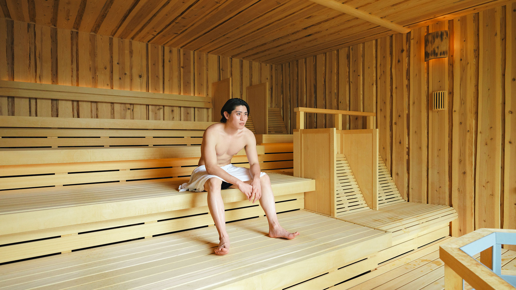 【最高の湯／ハイブリッドサウナ】広めの四段式。ベンチ2席・寝そべり2席・丸太スツール2席あります。