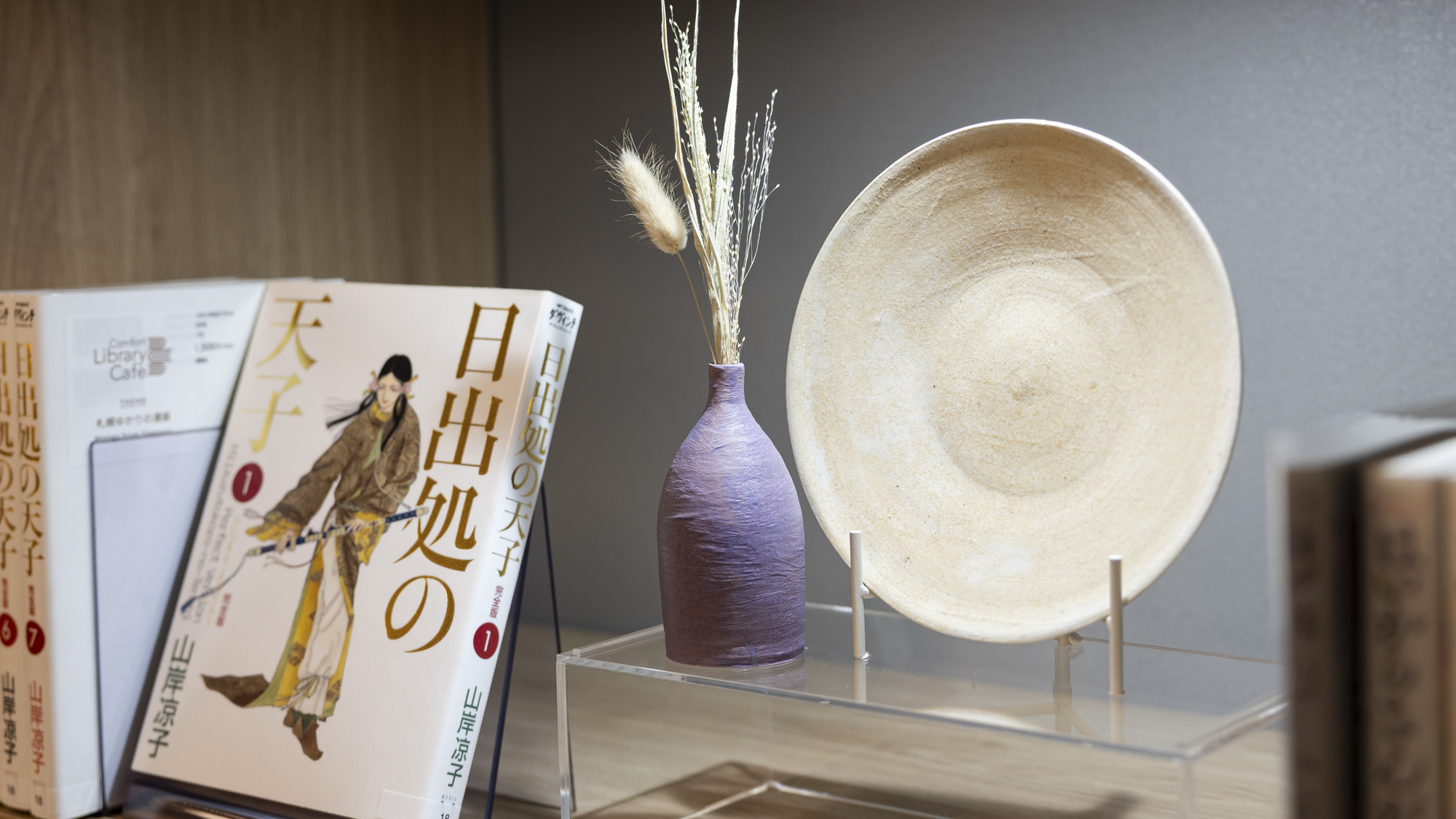 【ライブラリーカフェ】札幌の作家が作った作品をカフェ内に展示。近くに関連する書籍が並んでいます。