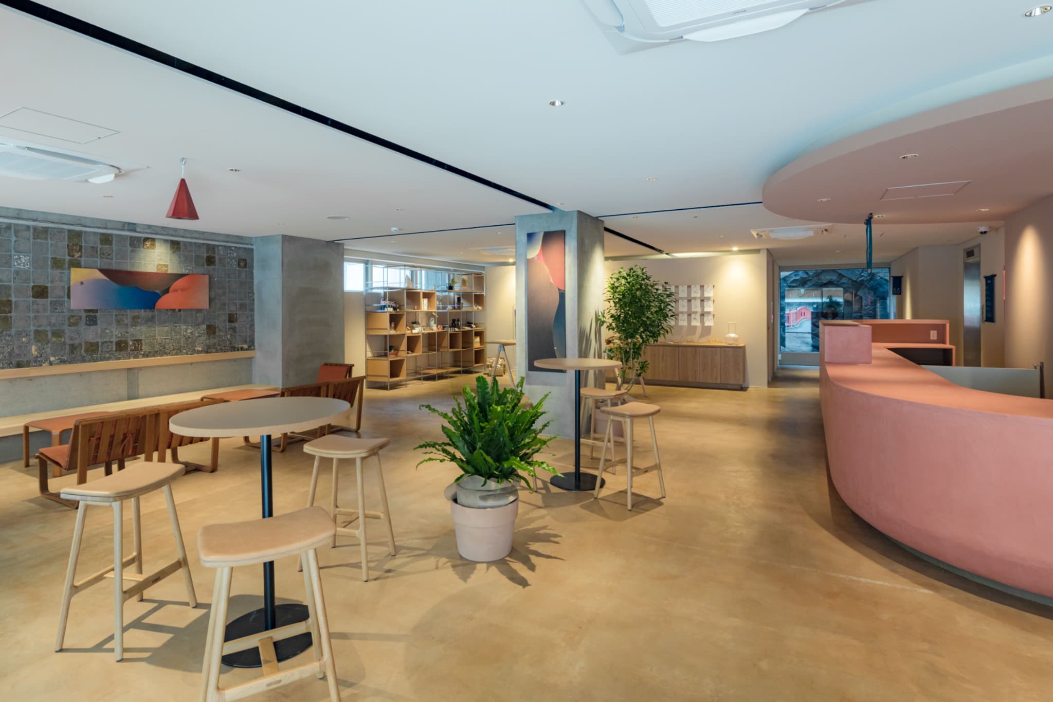 【ラウンジ1F】チェックインやご案内を行うフロントに、アートや物販が並ぶラウンジスペース