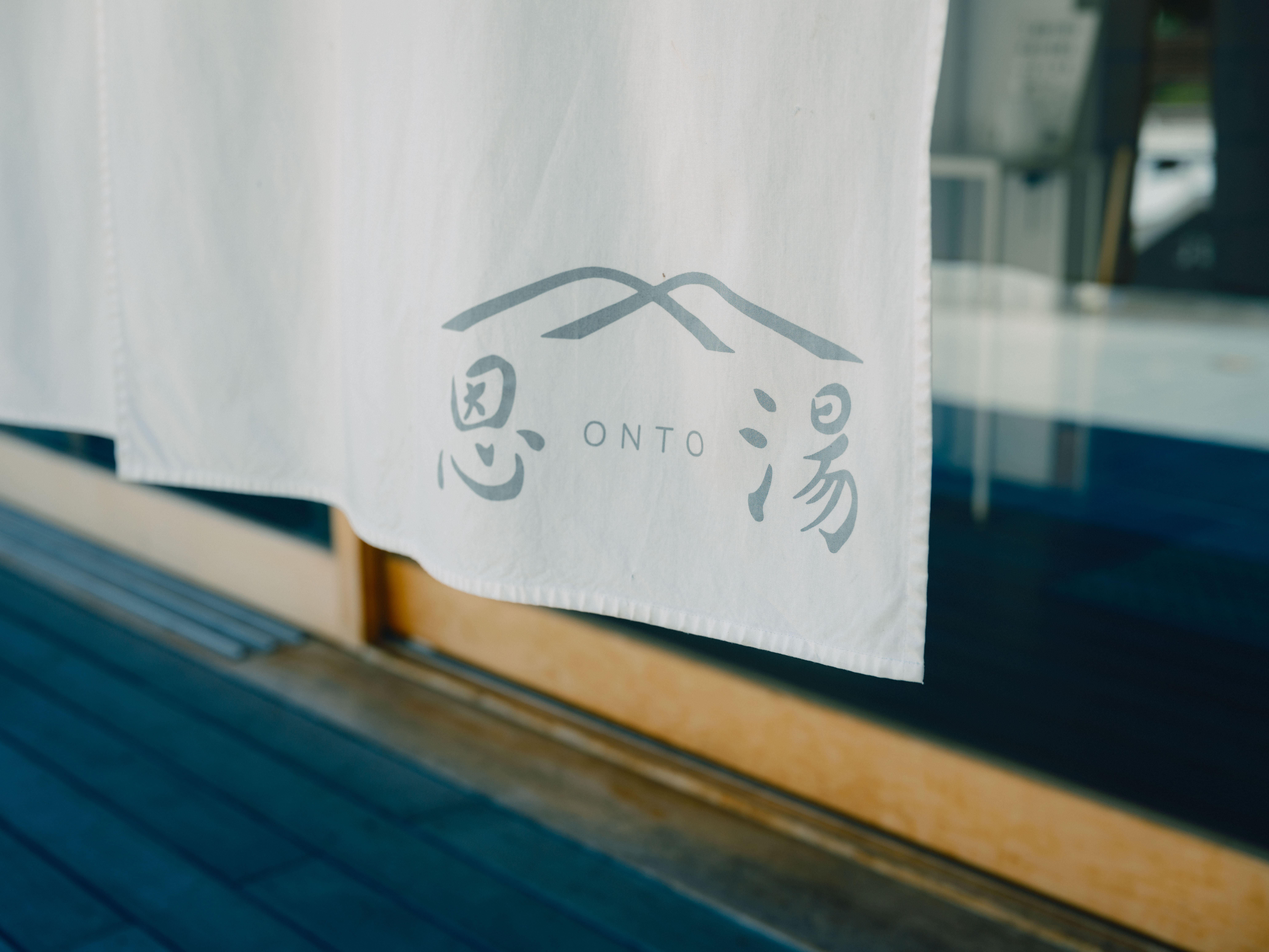 【恩湯】岩盤から湧出するお湯の流れを表現したロゴデザイン