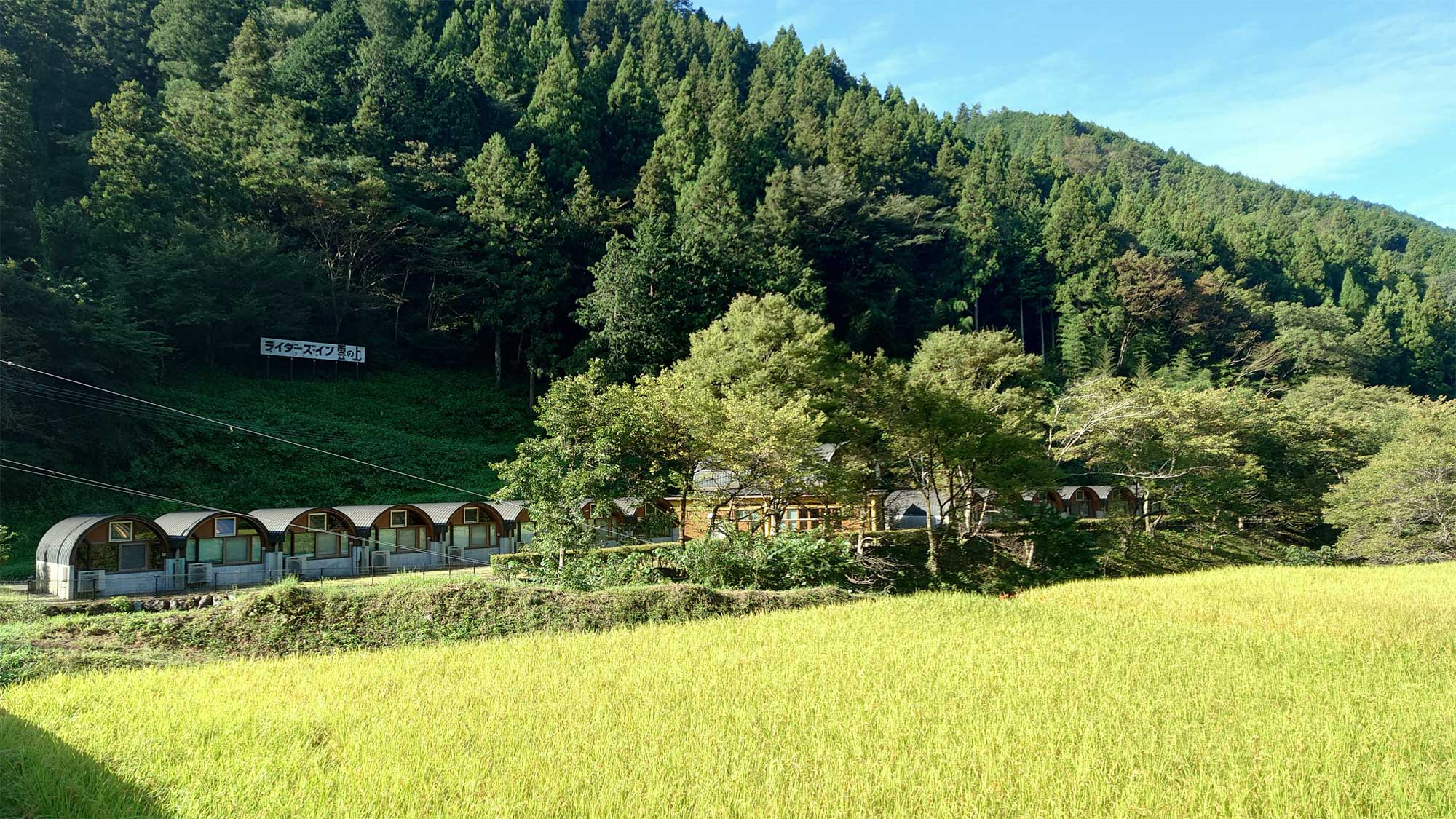 【外観】川を挟んで対岸の田んぼからの施設外観