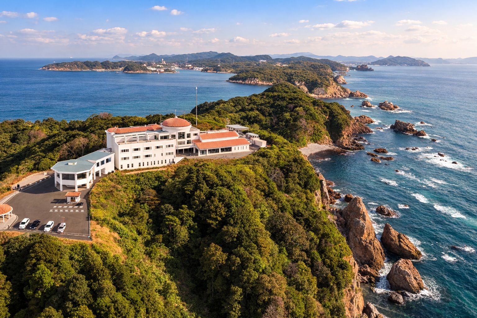 西海市崎戸町の先端に位置する「天海の城」。周囲を180度海に囲まれた絶好のロケーションと、プライベート感あふれる全14室の空間を空から捉えた全景写真です。