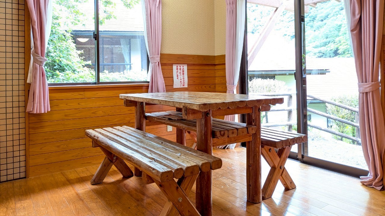 【平屋コテージC】ダイニングテーブル　窓の外はBBQスペース