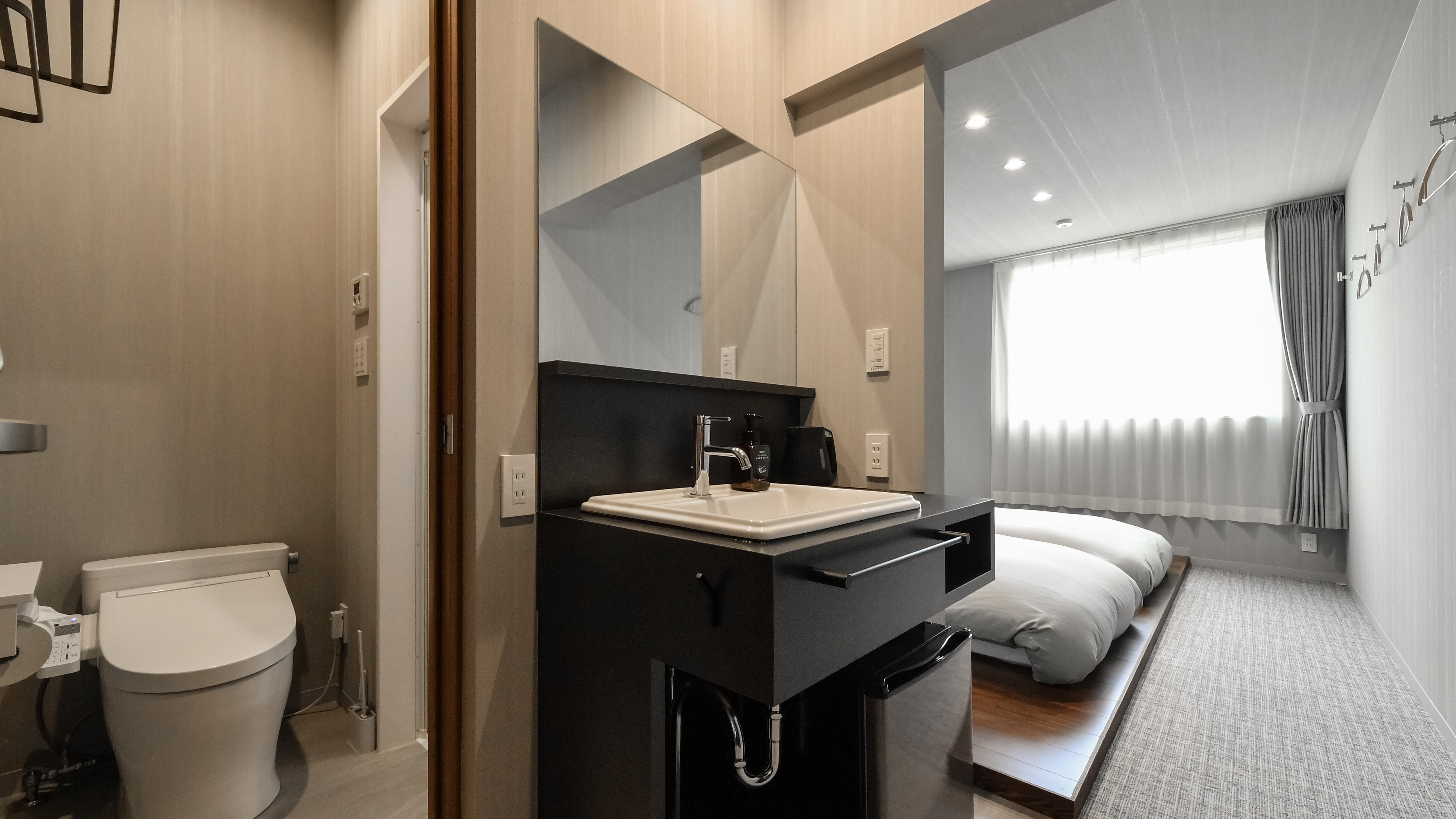 客室の入口から続く空間は、宿泊者が直感的に使いやすいように設計されています。洗面やトイレ・シャワー室が手前に配置されているため、すぐに利用できる安心感があります。奥には自然光に包まれた寝室が広がり、旅の疲れを癒す落ち着いた空間へと誘います。快適な導線設計は滞在中のストレスを軽減し、安心のホテルステイを提供します。