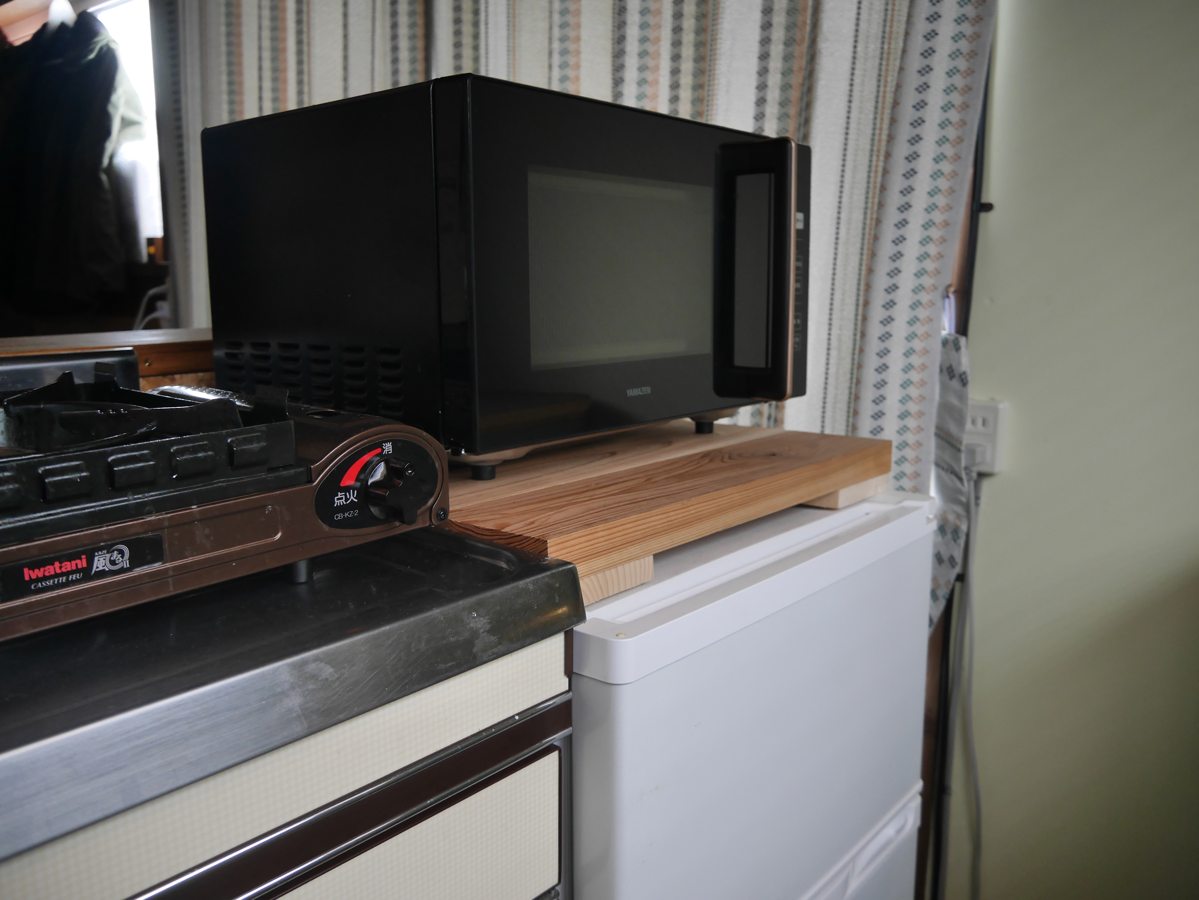 簡単な調理が可能なミニキッチン。冷蔵庫、電子レンジ、炊飯器、オーブントースター、調理器具、食器が設置されています