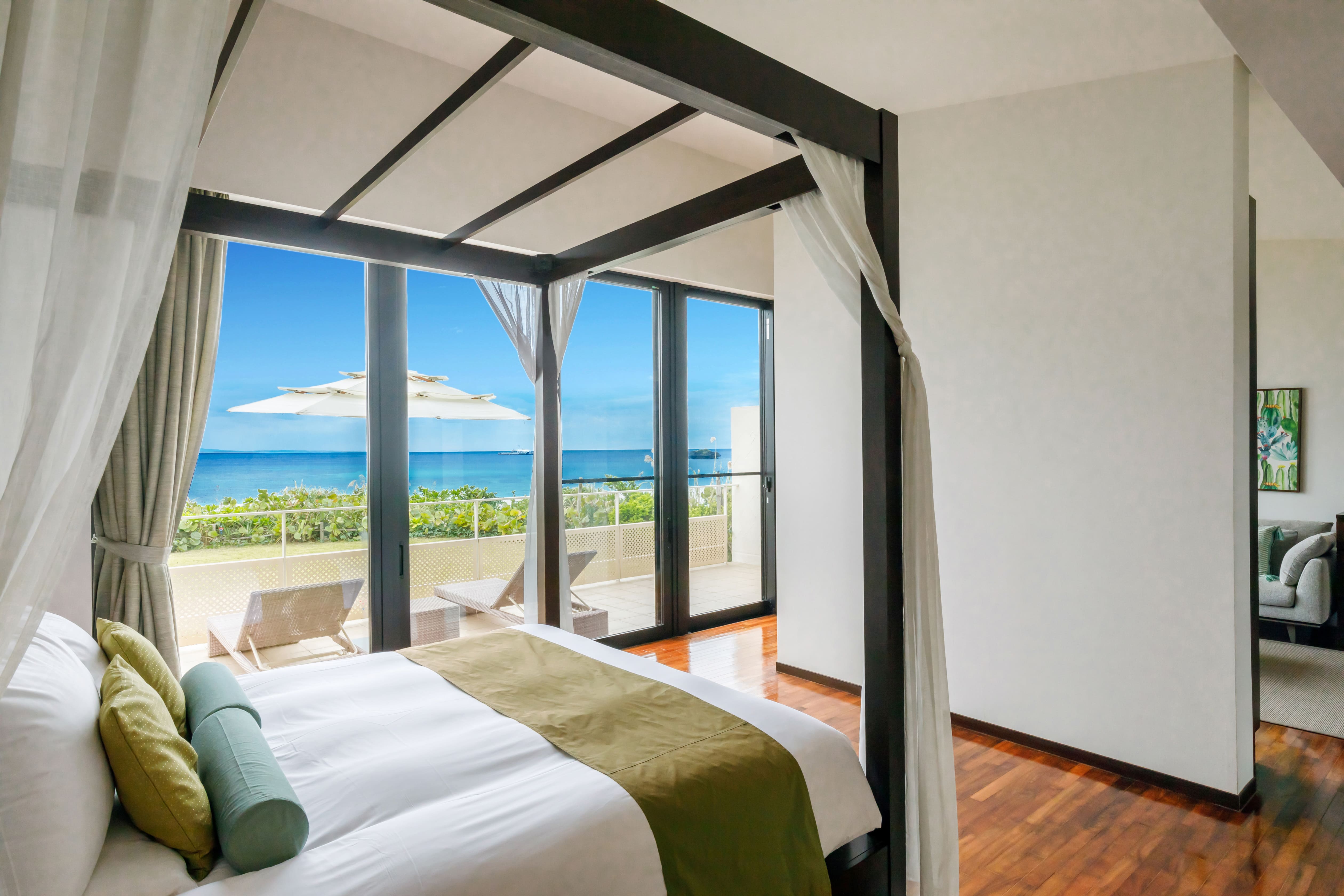 全室天蓋付きのキングサイズベッドのベッドルーム。名護ブルーの海を臨むオーシャンビューで素敵な目覚めを・・・。