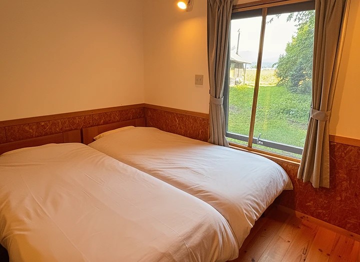 木の温もりに包まれて、深呼吸する夜。薫風舎コテージの静かな寝室。