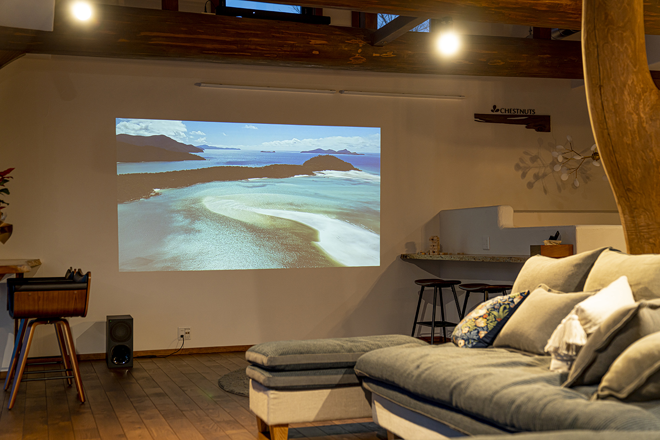 天井に吊り型のプロジェクターがあり、壁一面をスクリーンにして大画面でAmazonPrime VideoやDisney＋、YouTubeが自由に観られます。スピーカーとウーハーを起動させて臨場感あるミニシアターとしてお楽しみいただけることでしょう。