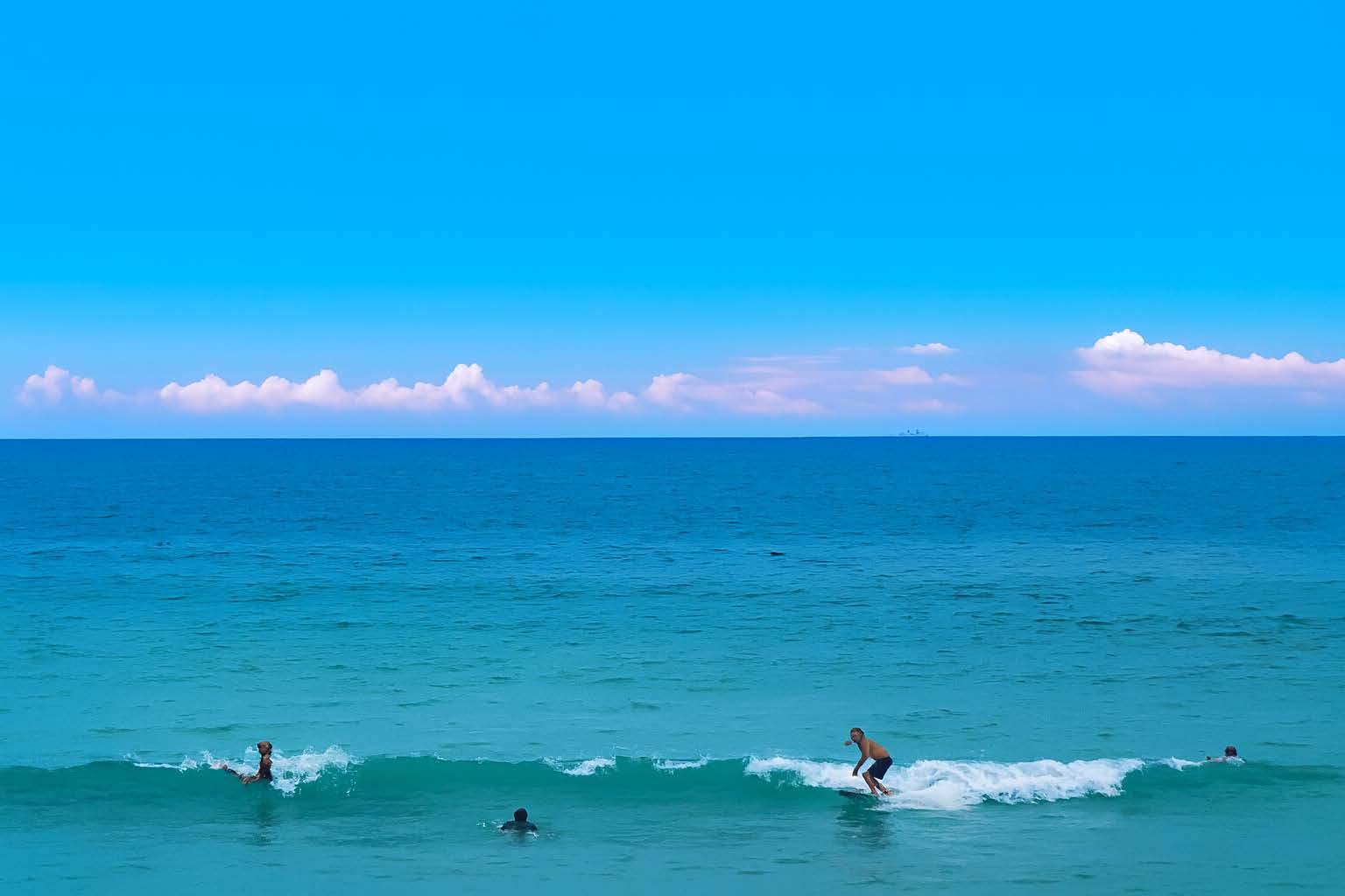 エメラルドの海とサーファー｜種子島で特別なひととき